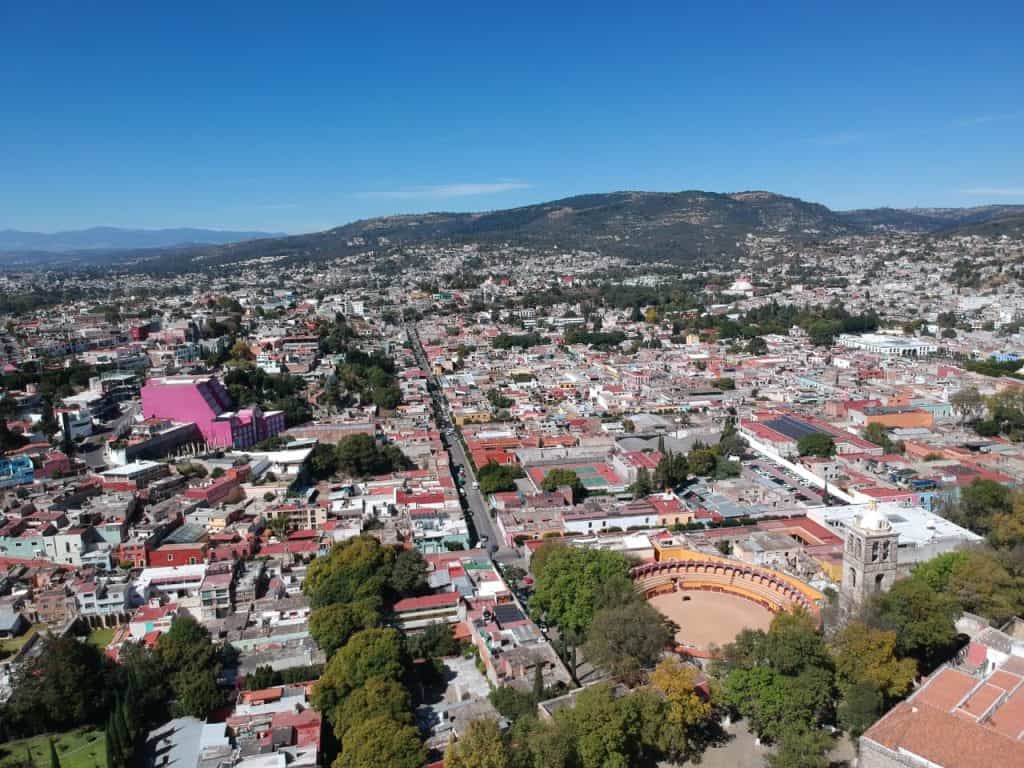 Tlaxcala vista aérea, ciudad rodeada de montañas y con un centro histórico lleno de edificios tradicionales y un ambiente tranquilo.