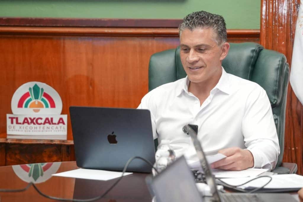 Hombre en reunión laboral con laptop en oficina de Tlaxcala.