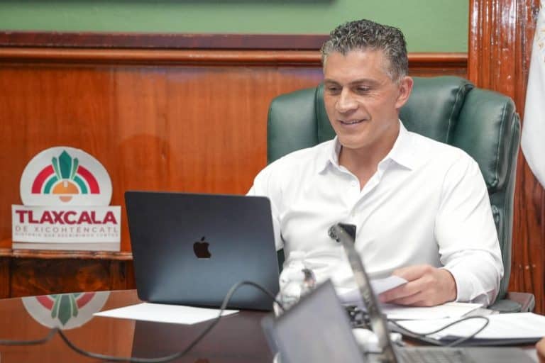 Hombre en reunión laboral con laptop en oficina de Tlaxcala.