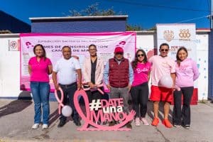 Campaña de concientización sobre el cáncer de mama en Tlaxcala con participación comunitaria y elementos en color rosa.