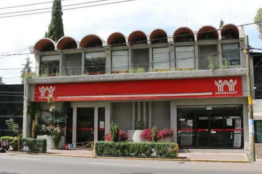 Archivos de una oficina de servicios en Tlaxcala, México, en un edificio de dos pisos con un logotipo de INFORNAVT en la fachada.