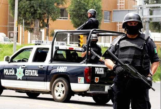 Armado policía estatal en patrulla en la calle en un operativo policial en Tlaxcala, México.