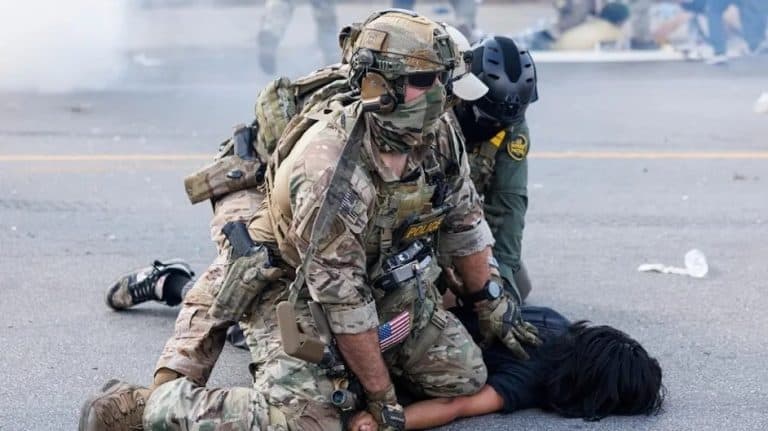 Operativos de seguridad rescatan a una persona en el suelo después de un incidente en la calle. Los oficiales usan equipo táctico y protección para controlar la situación y brindar ayuda inmediata.