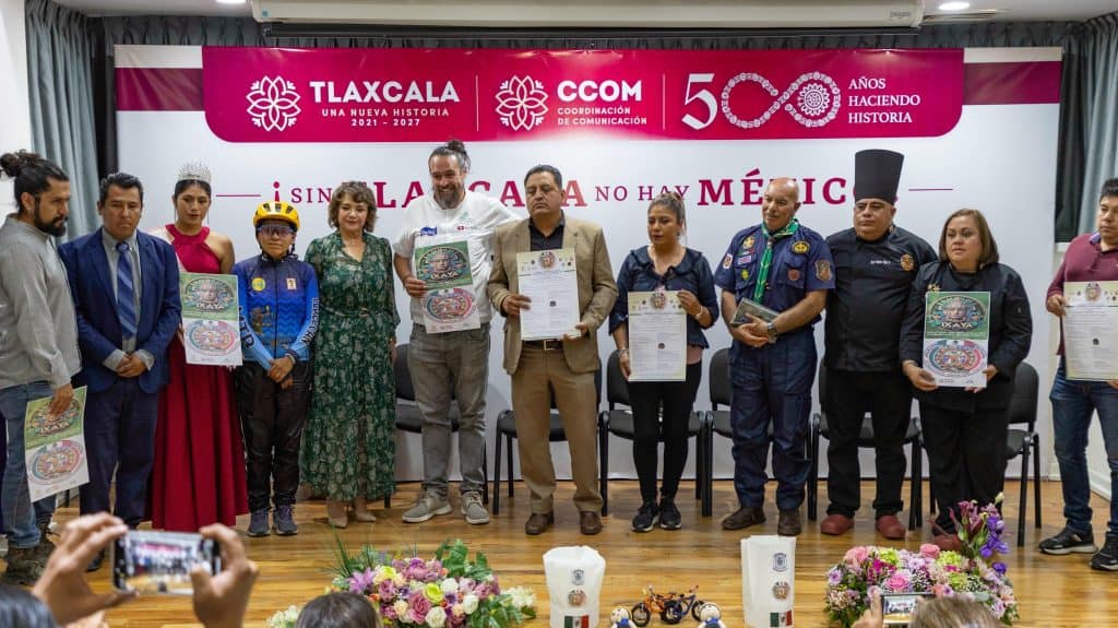 Reconocimiento a las autoridades y organizaciones durante una ceremonia en Tlaxcala, celebrando 50 años de historia y la colaboración en la promoción de la cultura y la historia local.