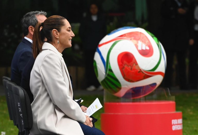 Futbol Mundial, Mujer observando balón de fútbol en evento internacional.