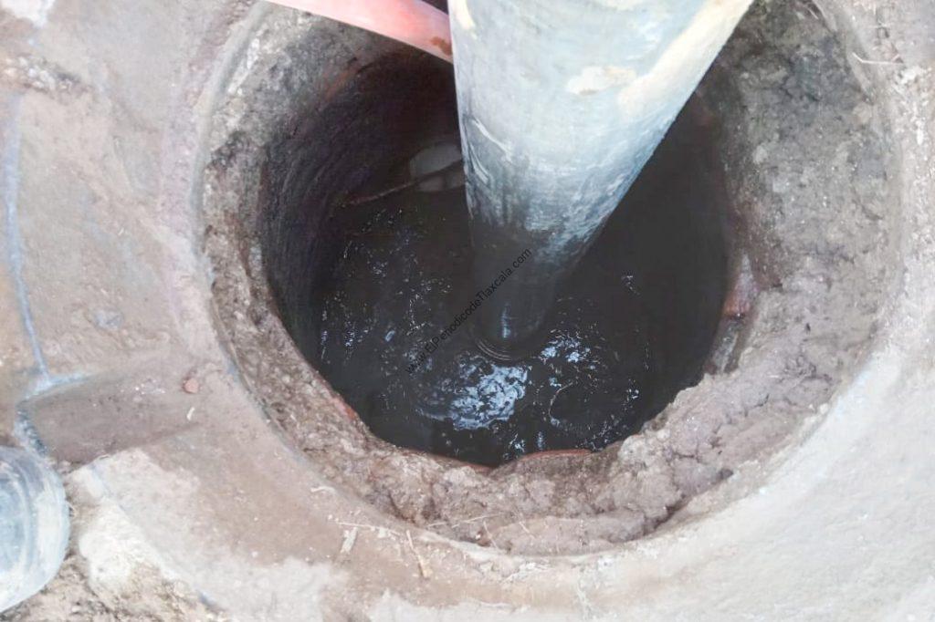 Buzón de alcantarillado abierto con tapa removida, exposición a contaminación y riesgo para la comunidad en Tlaxcala, México.