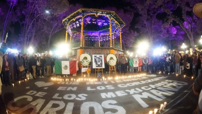 Homenaje en Tlaxcala por los héroes caídos en la lucha por la independencia de México en una conmemoración con flores, velas, y una foto de un héroe nacional en el centro de una plaza iluminada.