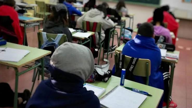 Estudiantes en un aula de clases, sentados en escritorios con materiales escolares, en un entorno educativo, participando en actividades académicas en un aula escolar.