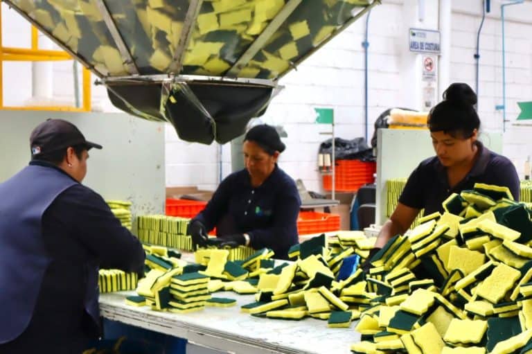 1. Personas trabajando en una línea de producción de esponjas de limpieza en una fábrica.