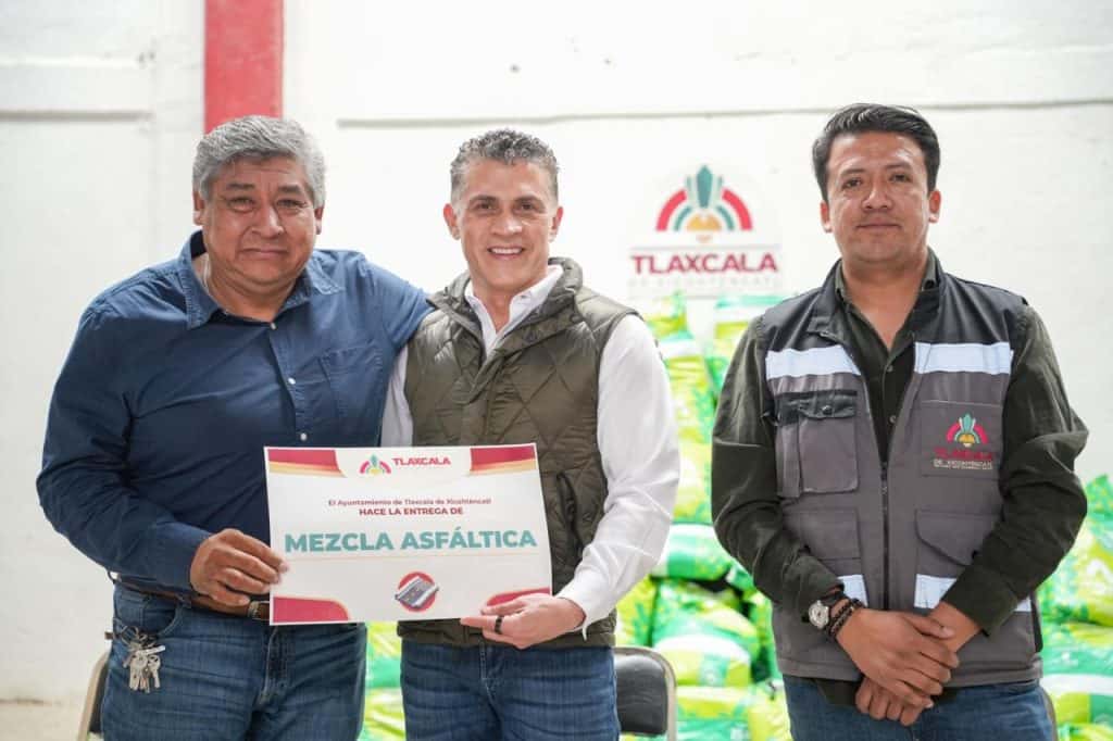 1. Personas entregando el certificado de cumplimiento para la pavimentación de la calle en Tlaxcala.
