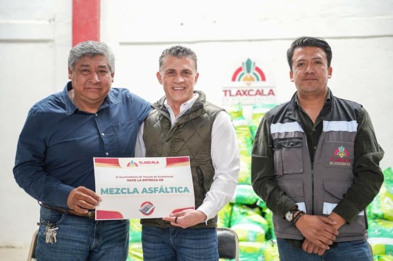 1. Personas entregando el certificado de cumplimiento para la pavimentación de la calle en Tlaxcala.