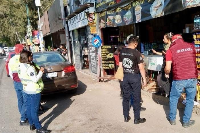 Personal de emergencia y autoridades atendiendo una situación en la calle frente a comercios en Tlaxcala, México.