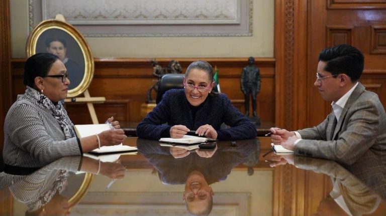 1. Mujer sonriente en reunión formal con dos colegas en oficina elegante, discutiendo temas importantes en un ambiente profesional.