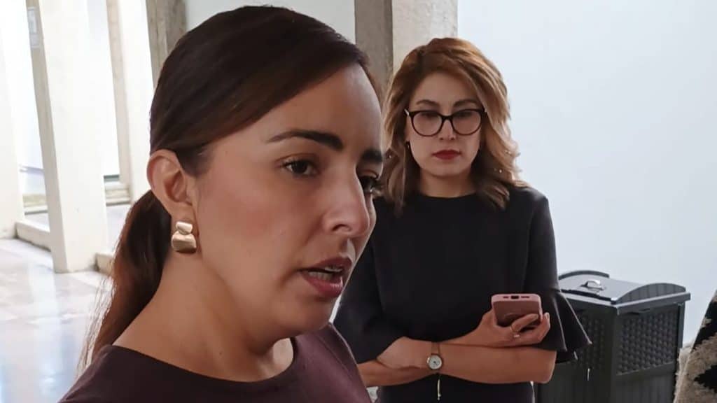1. Mujeres en una entrevista, una con cabello castaño oscuro y otra con cabello rubio y gafas, en un ambiente interior con luz natural.