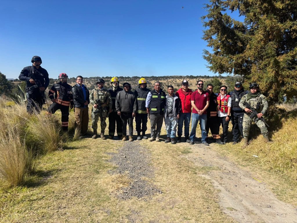 1. Equipo de emergencia y autoridades en un área rural con árboles y paisaje de fondo, participando en una operación conjunta.