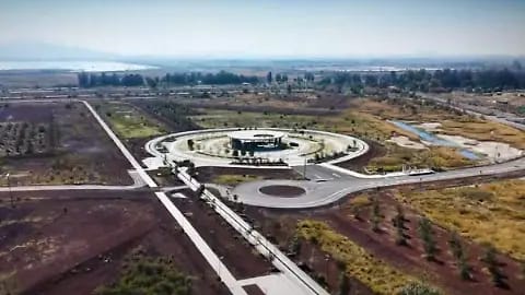 Aeropuerto moderno y amplio en un paisaje rural con caminos y áreas verdes, rodeado de tierra agrícola y caminos pavimentados, en una imagen aérea que muestra su planificación y estructura.