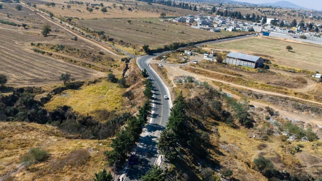 1. Carreteras rurales en Tlaxcala con paisaje agrícola y urbanización en el horizonte.