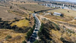 1. Carreteras rurales en Tlaxcala con paisaje agrícola y urbanización en el horizonte.