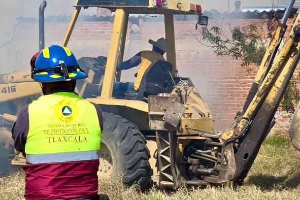 1. Persona de protección civil observando un tractor en medio de los daños por un incendio en Tlaxcala.