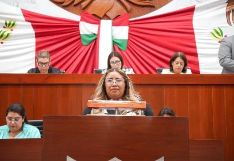 1. Mujeres en una sesión del Congreso de Tlaxcala, con fondo de bandera nacional y decoraciones tradicionales, participando en actividades legislativas.