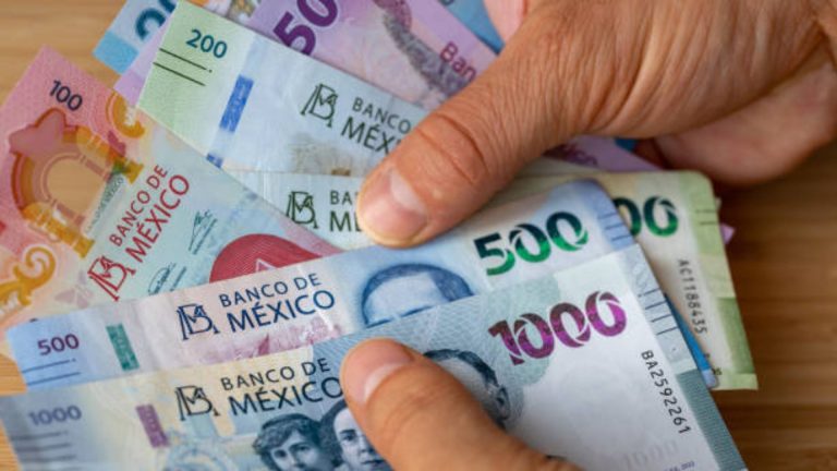 Billetes de diferentes denominaciones del peso mexicano, incluyendo 50, 100, 200, 500 y 1000 pesos, en manos de una persona.