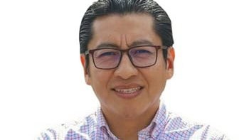 1. Hombre con gafas, sonrisa y camisa a cuadros, imagen de perfil cercano, en un fondo blanco, representando a un periodista o figura pública mexicana.