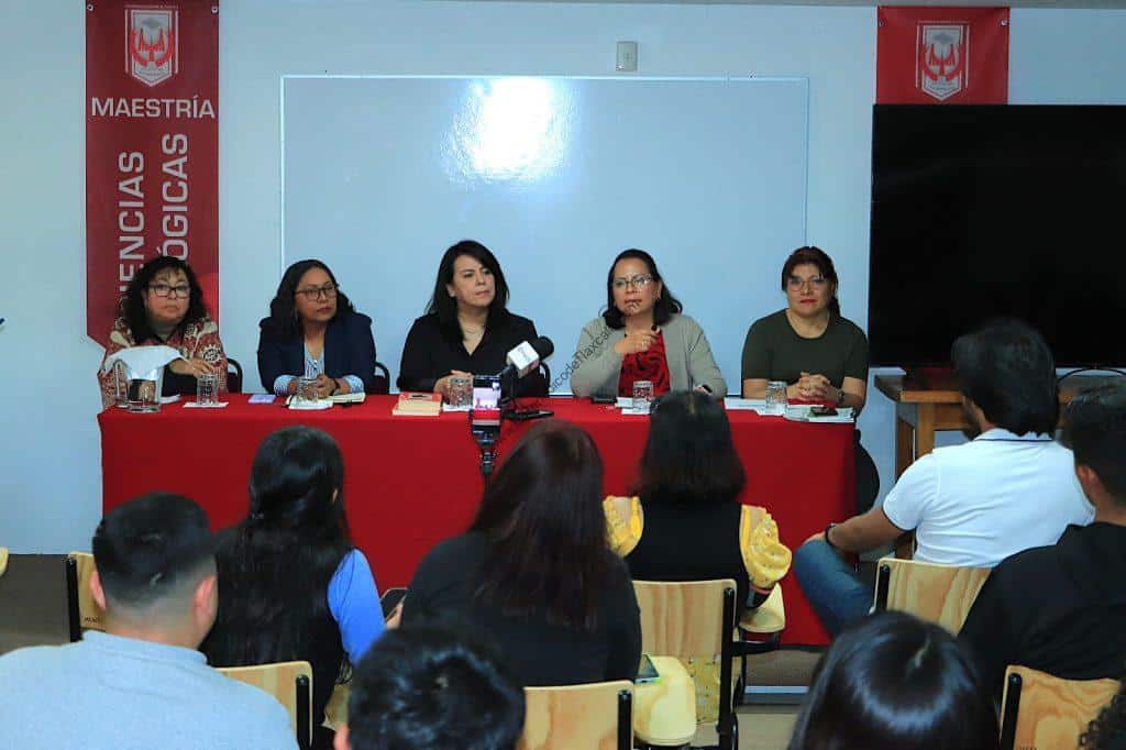 Panel de mujeres en una mesa durante una conferencia en un aula universitaria en Tlaxcala, México.