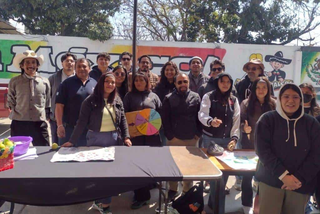 Árbol de decisiones con personas en un evento al aire libre, en un espacio con graffiti en la pared de fondo, durante el día.