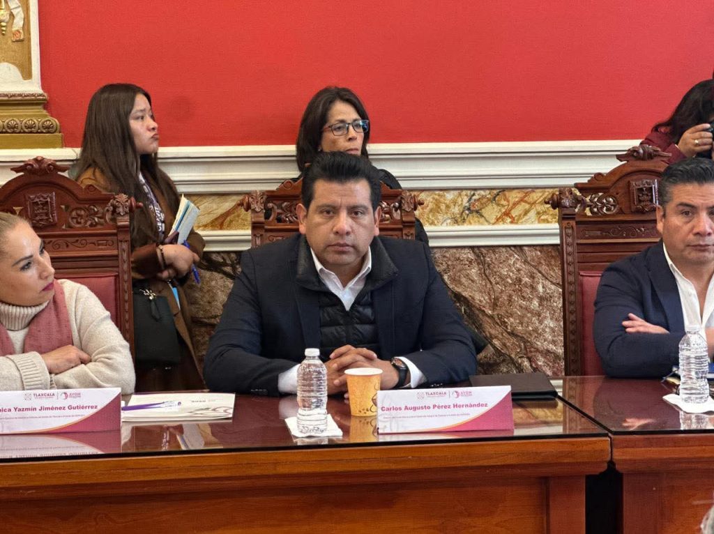 Reunión formal con varios asistentes en una sala con decoración clásica y mobiliario de madera.