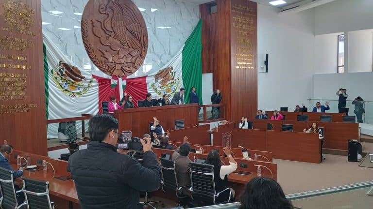 Audiencia en una sala de sesiones del Congreso de Tlaxcala con legisladores y asistentes durante una sesión parlamentaria.