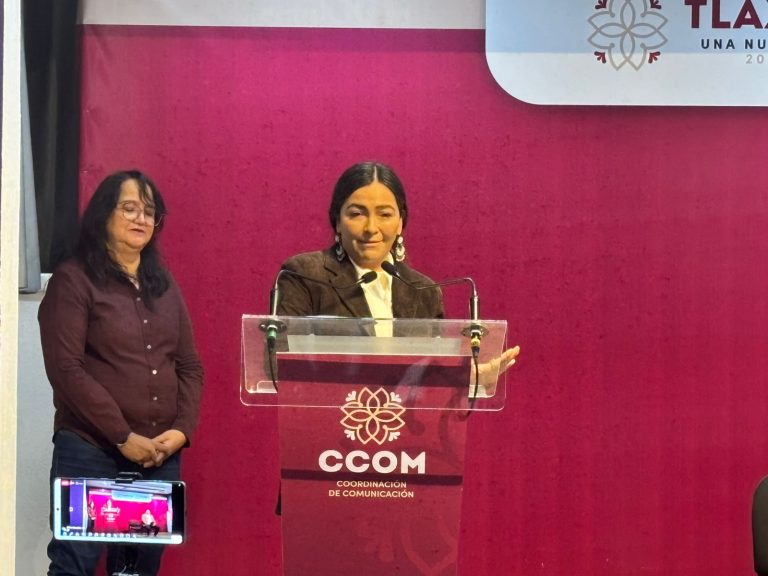 Dos mujeres en un evento, una hablando en un podio y otra de pie a su lado, con fondo rosa y logotipo de la CCQM en Tlaxcala.