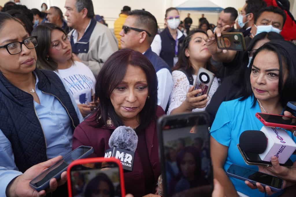 Mujeres y periodistas en una rueda de prensa al aire libre, rodeadas de medios y asistentes, en un evento público en Tlaxcala, México.