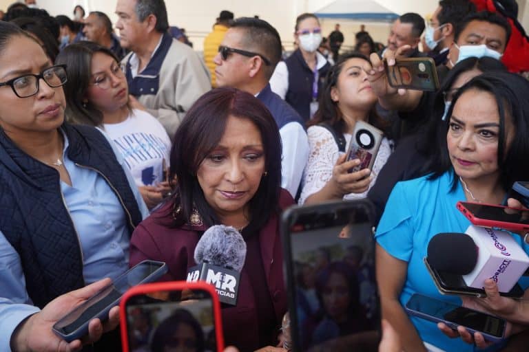 Mujeres y periodistas en una rueda de prensa al aire libre, rodeadas de medios y asistentes, en un evento público en Tlaxcala, México.