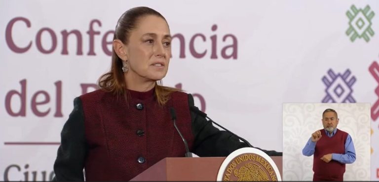 La mujer en la conferencia del gobierno, hablando en un podio con un fondo con logotipos y texto en español.