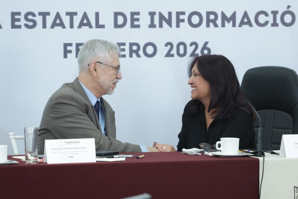 Persona mayor y mujer en una reunión formal, estrechándose la mano en un evento de información en Tlaxcala, México, en febrero de 2026.