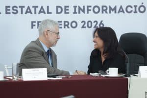 Persona mayor y mujer en una reunión formal, estrechándose la mano en un evento de información en Tlaxcala, México, en febrero de 2026.