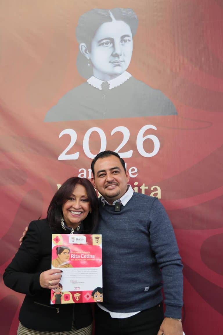 Dos personas sonriendo y sosteniendo un certificado en un evento con un fondo que muestra una imagen histórica y el año 2026.