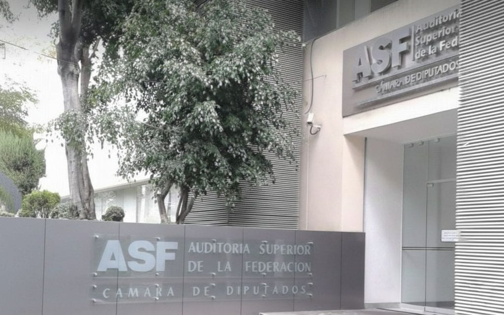 Fachada del edificio de la Auditoría Superior de la Federación en Tlaxcala, con árboles y señalización visible.