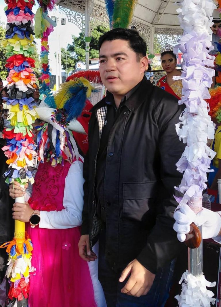 Hombre en celebración tradicional con decoraciones coloridas en un evento cultural en Tlaxcala, México.