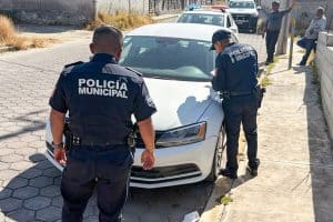 POLICÍA MUNICIPAL INSPECCIONANDO UN VEHÍCULO EN LA CALLE, DURANTE UNA OPERATIVA DE SEGURIDAD EN TLAXCALA.