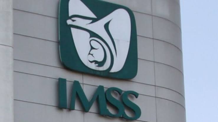 Automóvil de la marca IMSS en un edificio institucional en Tlaxcala, México, con el logotipo visible en la fachada.