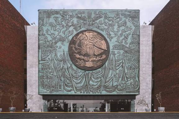 Árbol de la vida en relieve en la fachada del Museo de Tlaxcala, con detalles escultóricos que representan la historia y cultura de la región, en un diseño moderno y simbólico.
