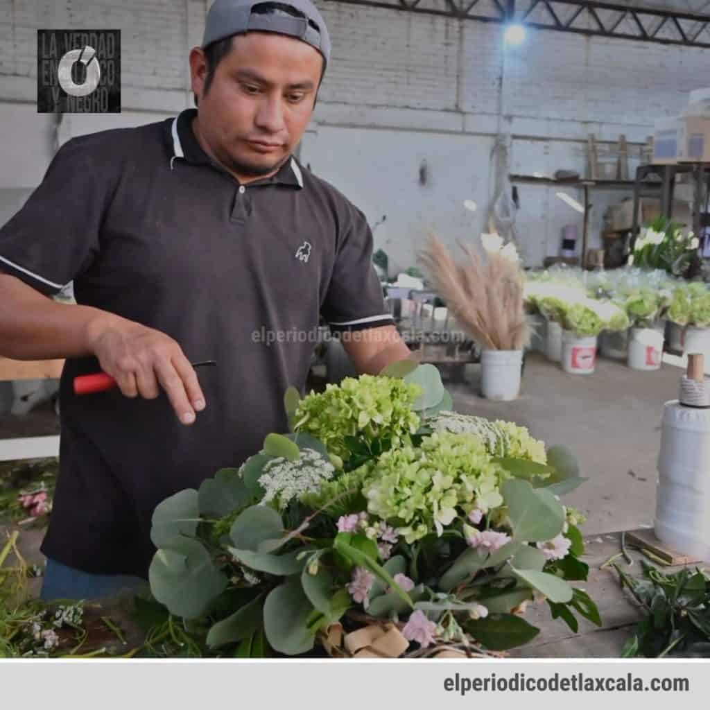 Joven florista preparando un arreglo floral en un taller de flores en Tlaxcala, México.
