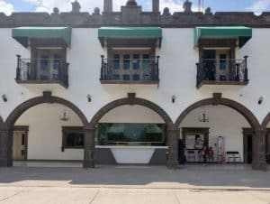 Fachada de edificio colonial con arcos y balcones en Tlaxcala, México, en un día soleado.