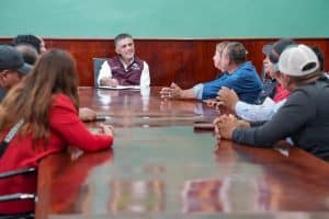 Reunión de un grupo de personas en una sala de conferencias, discutiendo temas importantes en un ambiente formal y colaborativo.