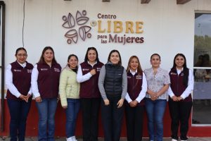 La imagen muestra a un grupo de siete mujeres en frente del Centro Libre para las Mujeres, en Tlaxcala, México, posando juntas y sonriendo, promoviendo la igualdad y el empoderamiento femenino.