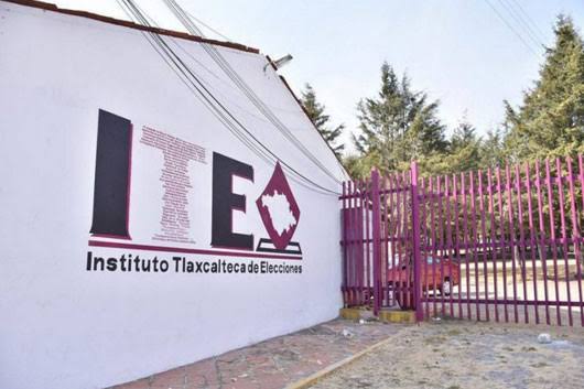 Fachada del Instituto Tlaxcalteca de Elecciones con muro y portón rosa en Tlaxcala, México.