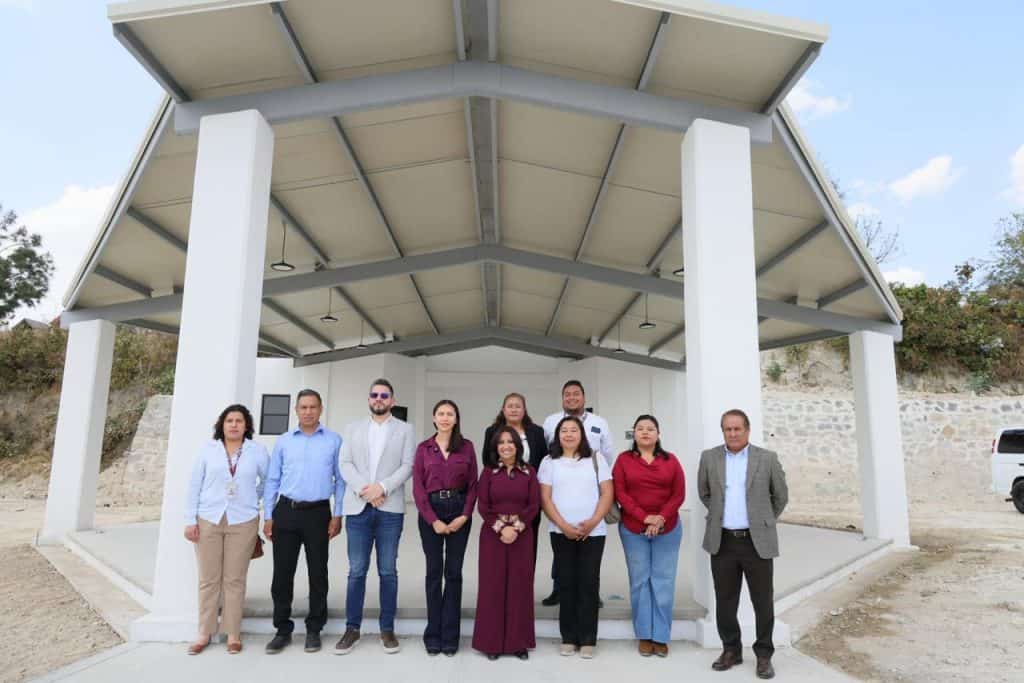 Grupo de personas en un espacio abierto con estructura moderna y techo de paneles solares, en Tlaxcala, México.