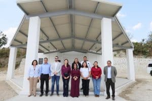 Grupo de personas en un espacio abierto con estructura moderna y techo de paneles solares, en Tlaxcala, México.