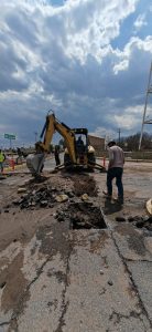Remoción de pavimento y reparación de infraestructura vial con maquinaria pesada en una calle de Tlaxcala, México, durante el día con cielo nublado.